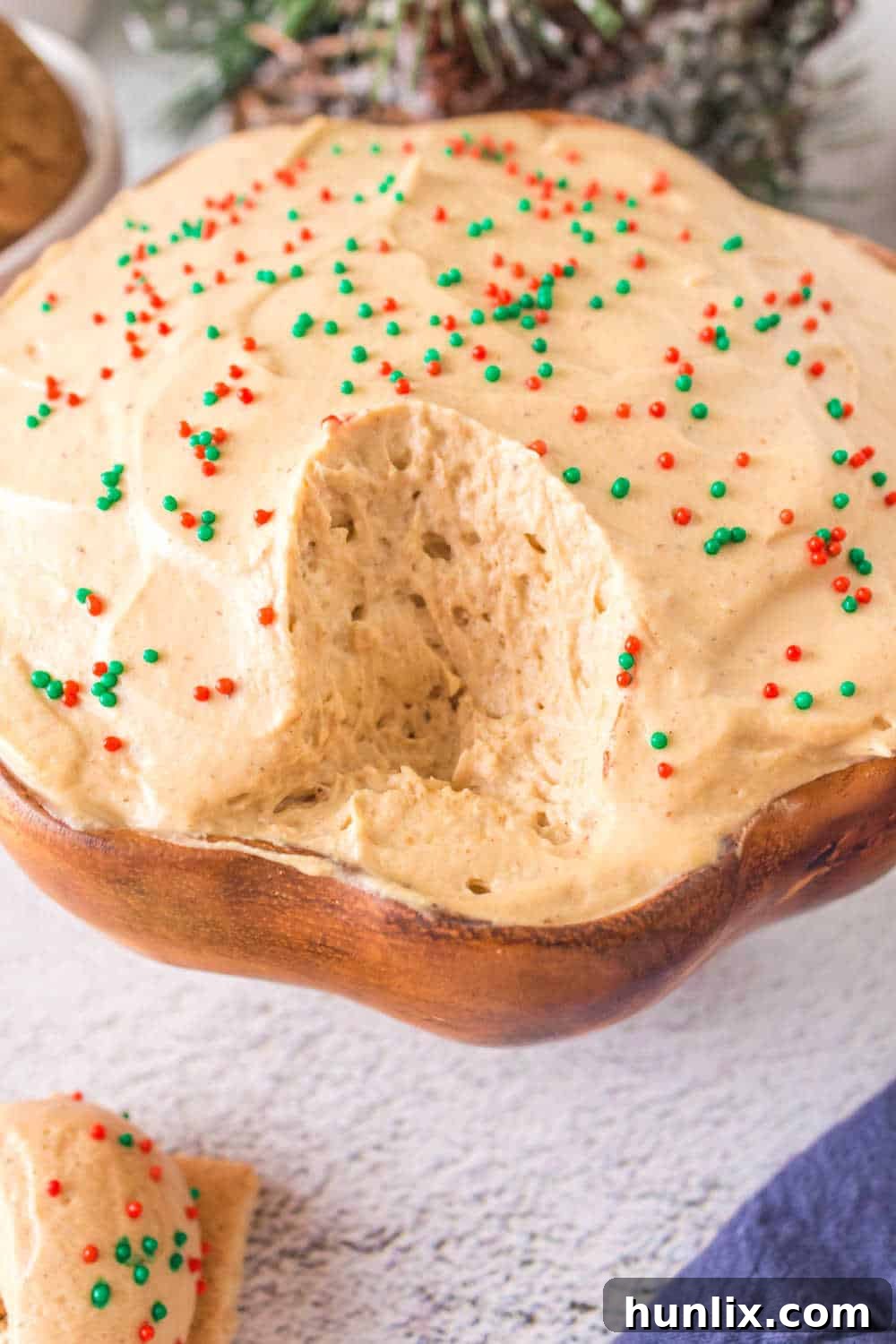 Spiced Gingerbread Delight 8 A bowl of gingerbread dip with a serving spoon and some of the dip already taken, showing its creamy texture.