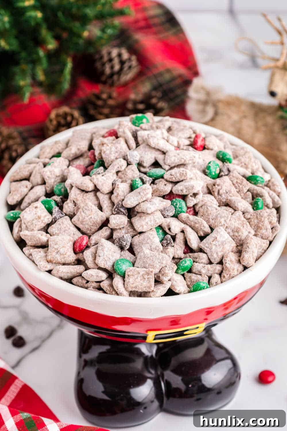 Reindeer Chow served in a festive Santa Claus themed bowl, ready for a Christmas party.