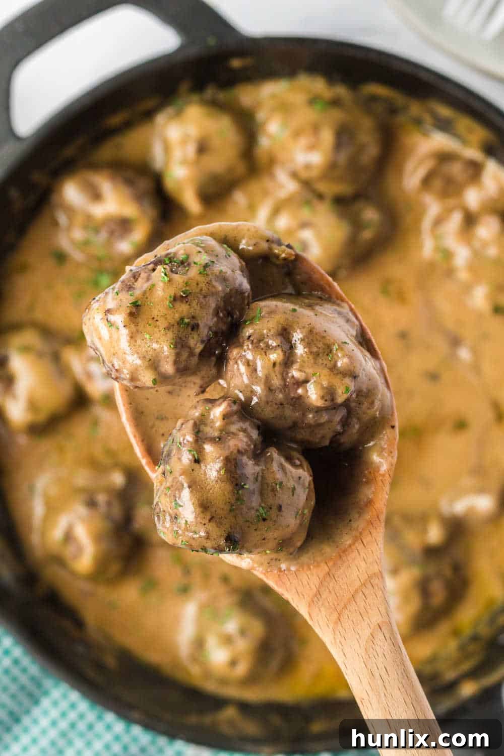 Traditional Swedish Meatballs 8 A single Swedish meatball on a serving spoon, covered in rich gravy.