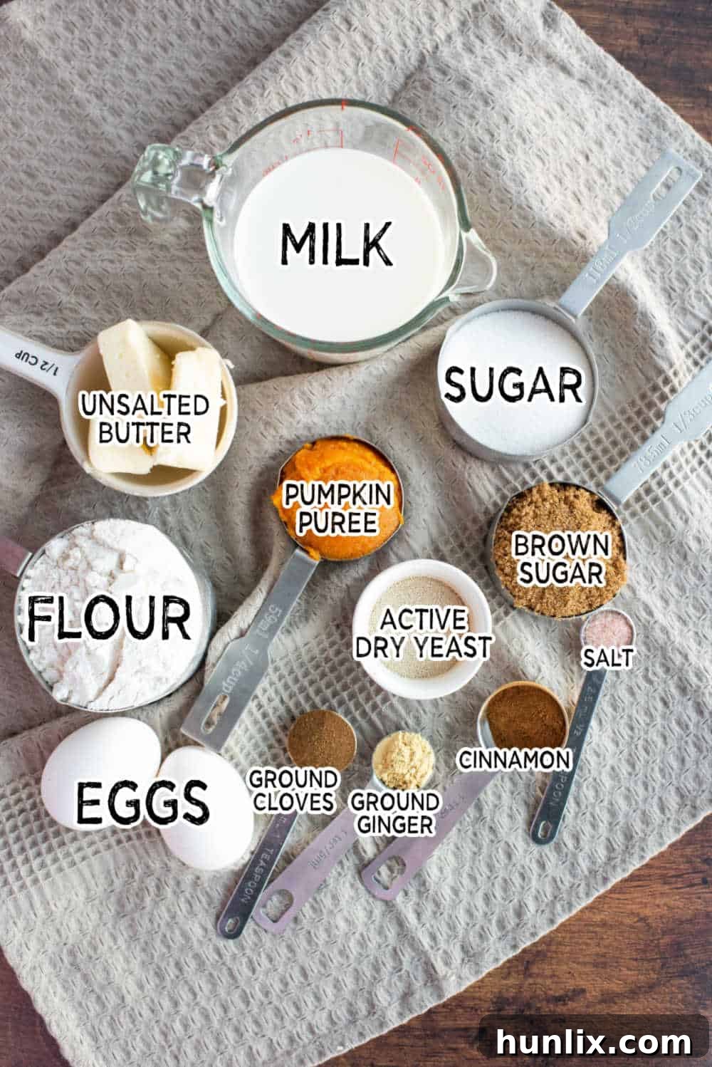 Pumpkin Spice Cinnamon Swirls 3 A selection of fresh ingredients including pumpkin puree, spices, flour, and butter, laid out for making pumpkin cinnamon rolls