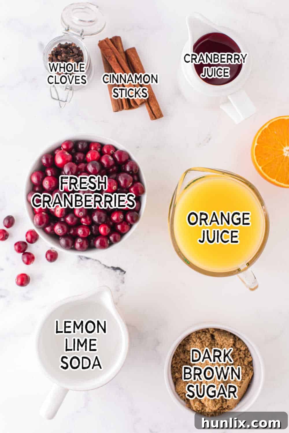 Crimson Spice Elixir 3 A vibrant collection of ingredients for Spiced Cranberry Punch, including bottles of cranberry and orange juice, a bowl of fresh cranberries, a bag of brown sugar, whole cloves, and cinnamon sticks, all artfully arranged on a clean white surface with good lighting.