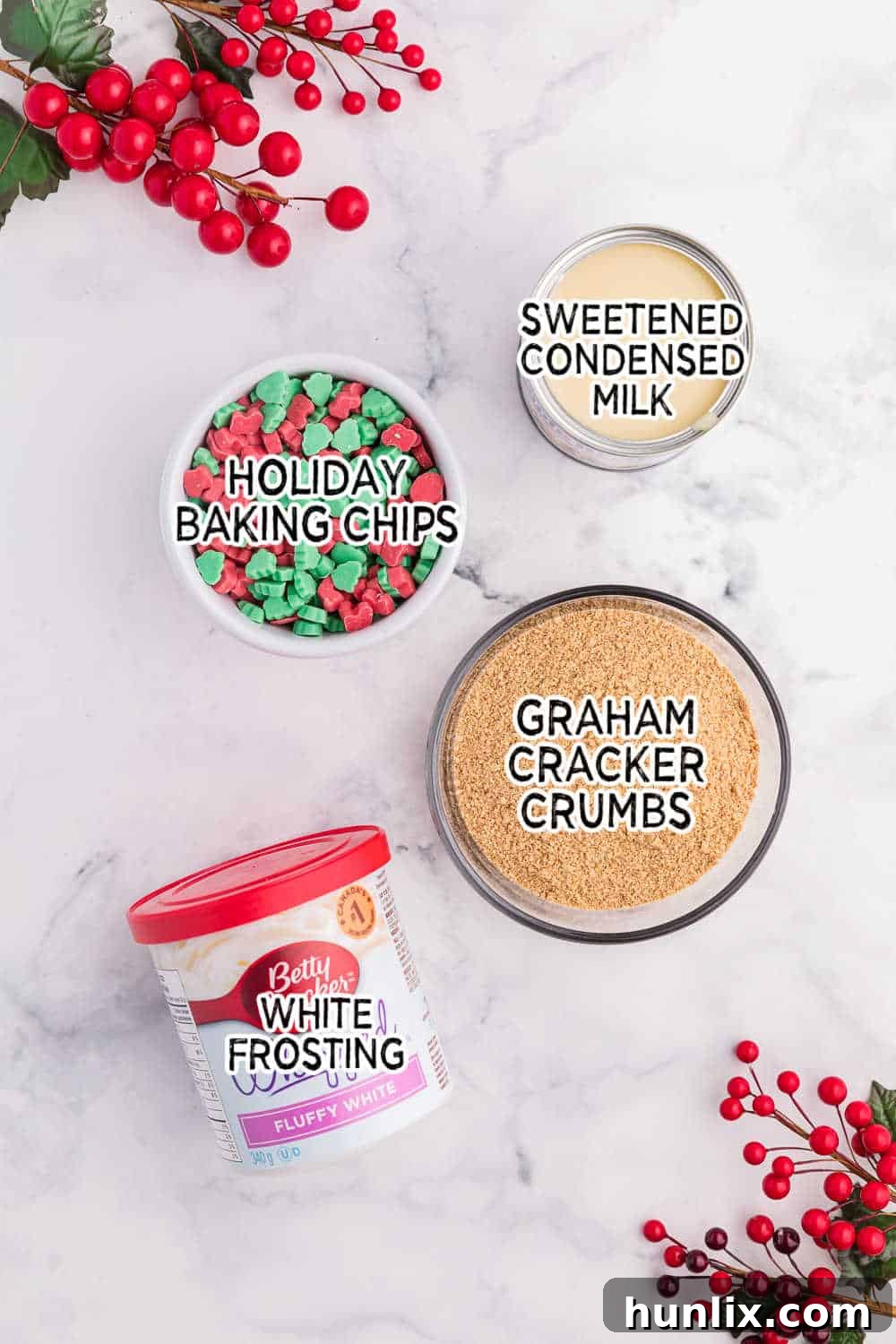 Four simple ingredients for Christmas Chewy Bars: graham cracker crumbs, condensed milk, holiday baking chips, and white frosting.