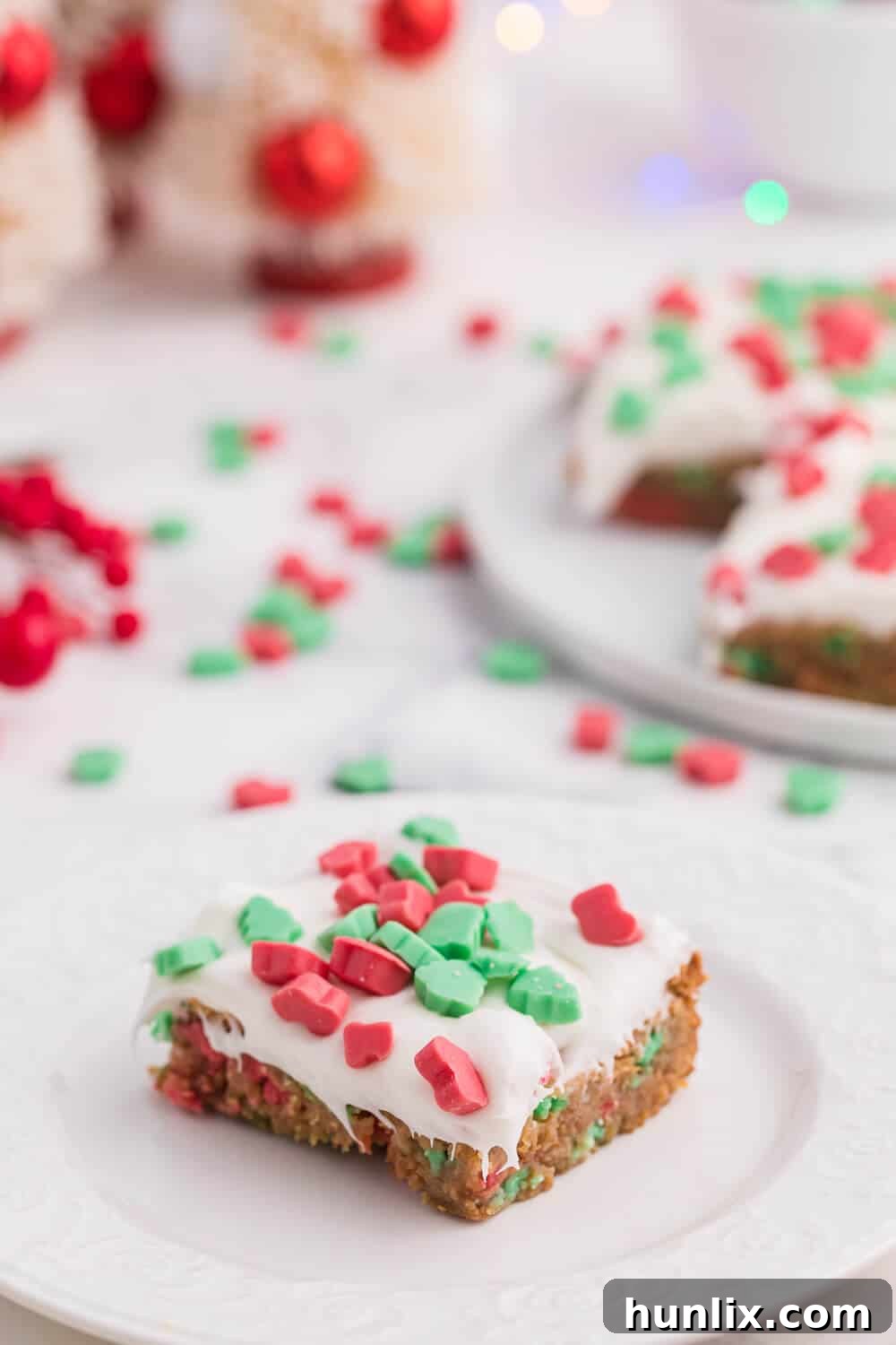 A single piece of Christmas Chewy Bar on a white plate, showcasing its layered texture and vibrant toppings.