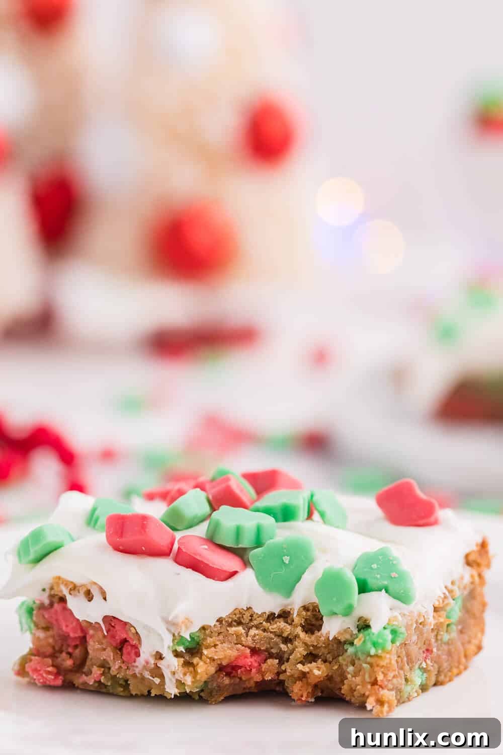 A delectable piece of Christmas Chewy Bar on a plate with a bite taken out, revealing its soft, chewy interior.