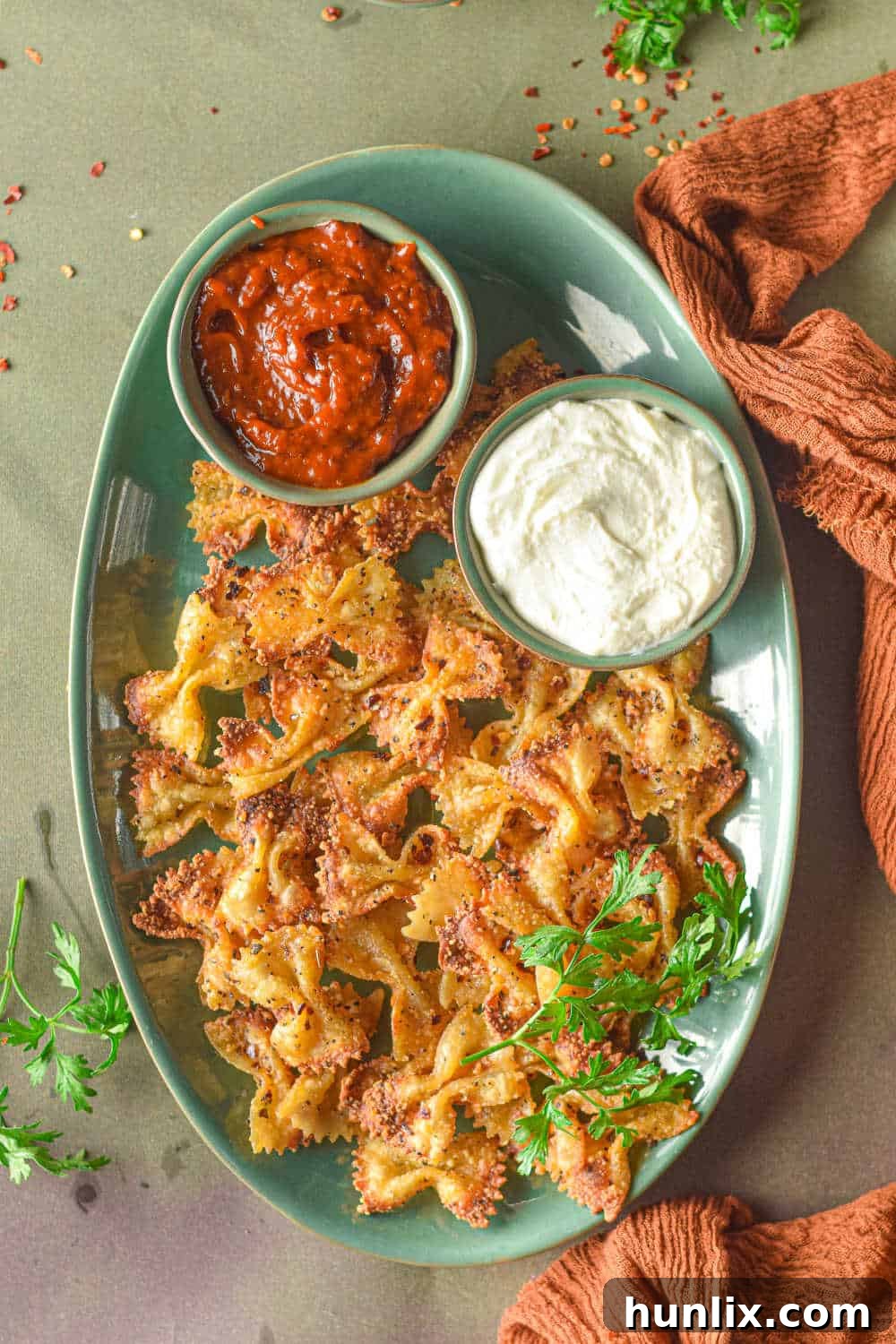 Air Fried Pasta Crisps 2 Air fryer pasta chips on a green platter with a bowl of feta dip, ready to be served.