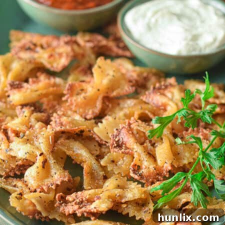 A plate of air fryer pasta chips with a side of dip.