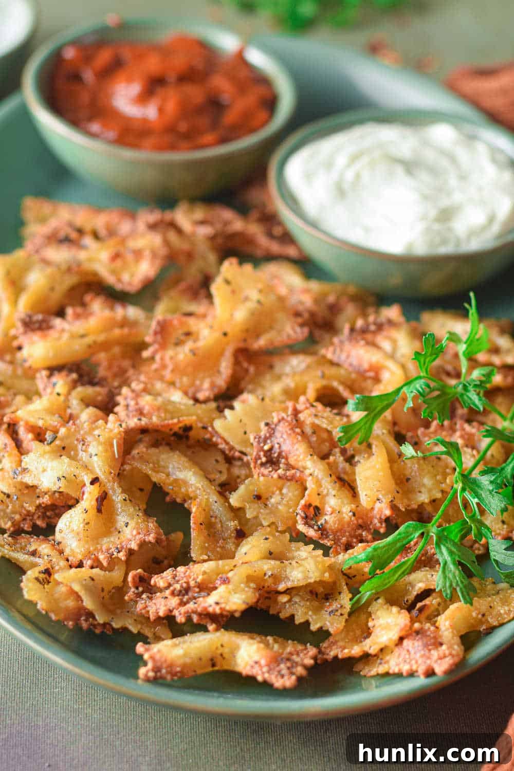 Air Fried Pasta Crisps 9 A close-up of crispy air fryer pasta chips on a platter, showcasing their golden texture and seasoning.