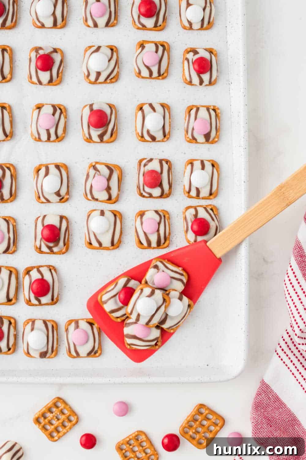 Pretzel Hugs on a baking sheet with a red spatula, showcasing their sweet and salty appeal.