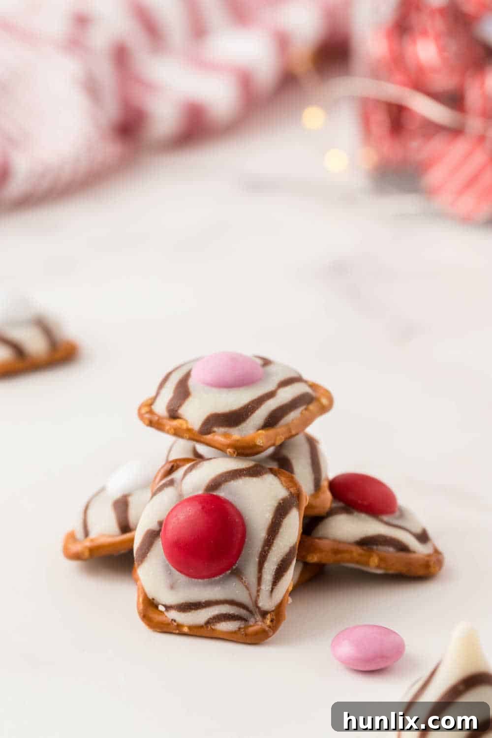 A stack of golden brown Pretzel Hugs with colorful M&M's, set against a clean white background.