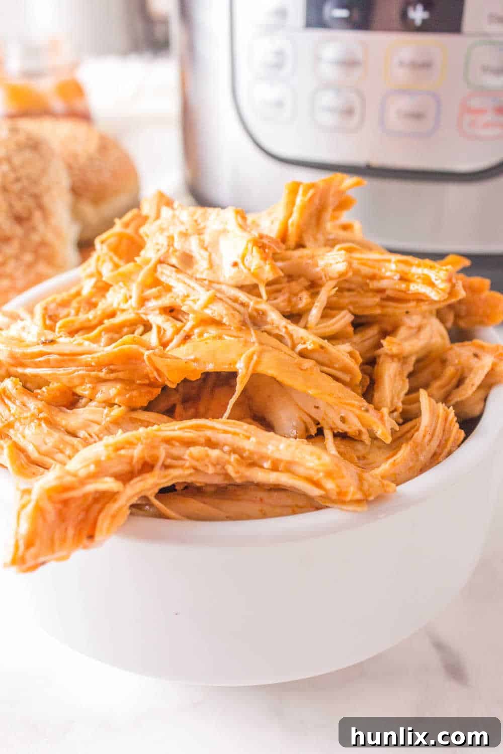 A serving of Instant Pot BBQ shredded chicken in a white bowl, ready to be enjoyed.