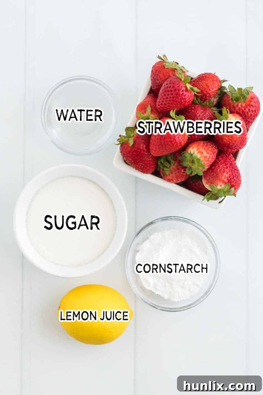 Effortless Instant Pot Strawberry Jam 4 Individual ingredients for Instant Pot Strawberry Jam, including fresh strawberries, a bowl of sugar, a lemon, and cornstarch, neatly arranged.