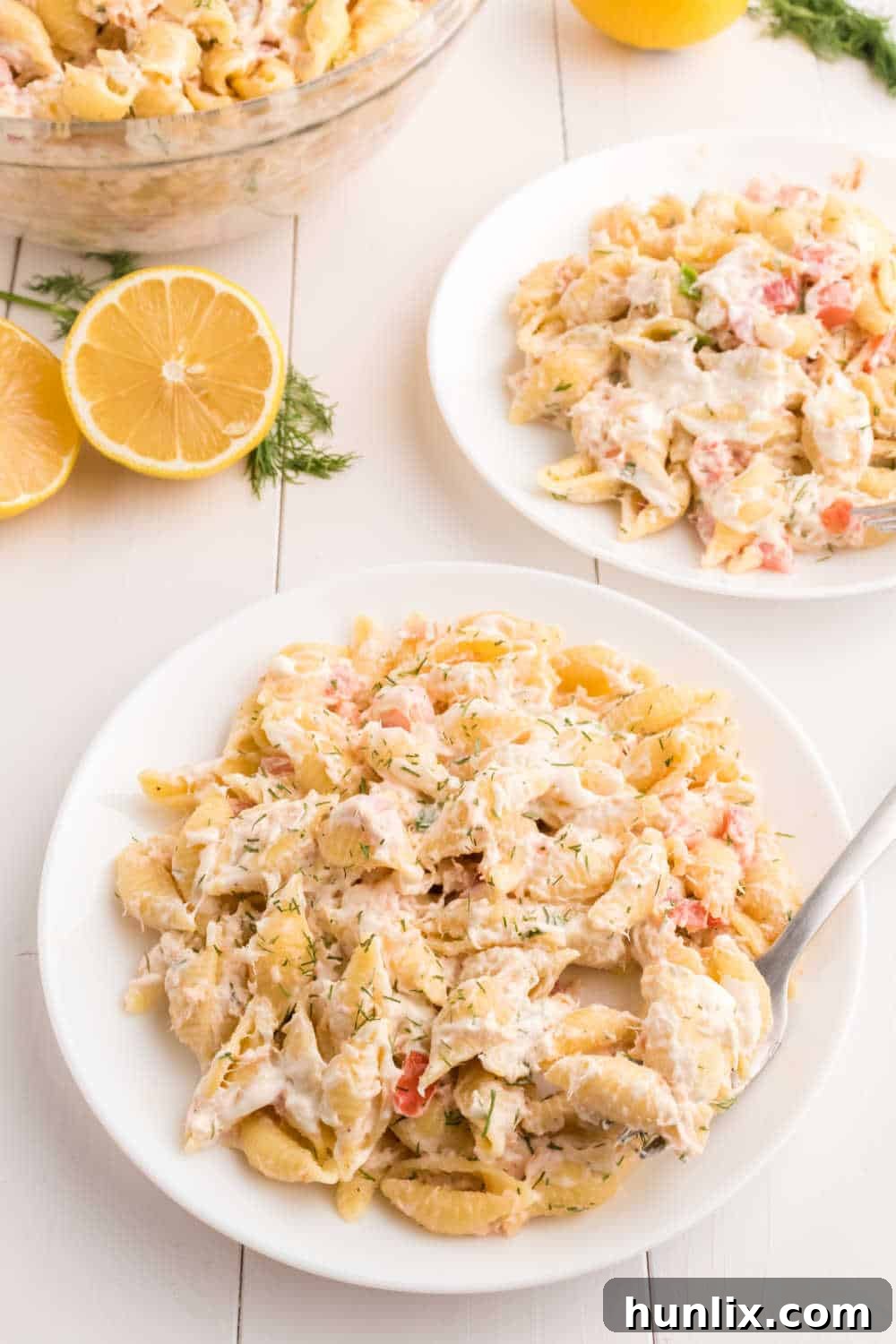 Zesty Shrimp Pasta Salad 10 A serving of creamy shrimp pasta salad on a white plate with a fork, garnished with fresh dill.