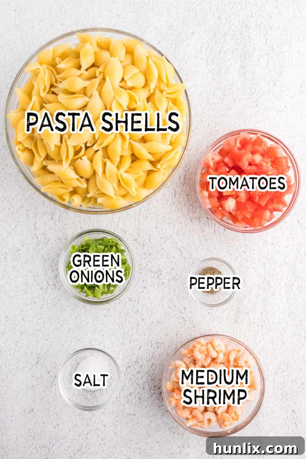 Zesty Shrimp Pasta Salad 3 A flat lay of fresh ingredients laid out, including pasta, canned shrimp, tomatoes, and green onions, ready for making shrimp pasta salad.