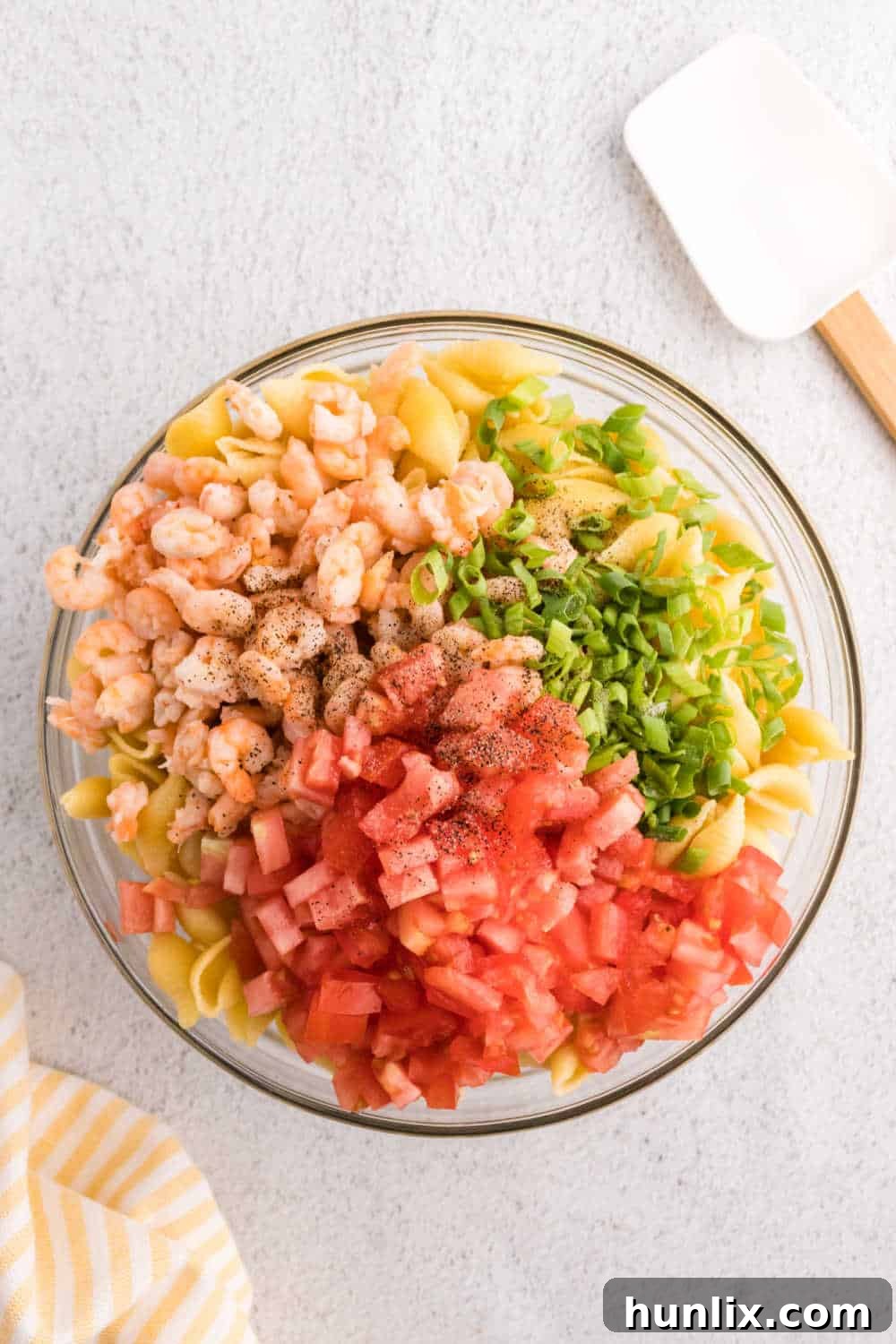 Zesty Shrimp Pasta Salad 5 Cooled pasta, drained shrimp, sliced green onions, and diced tomatoes mixed in a large bowl, seasoned with salt and pepper.