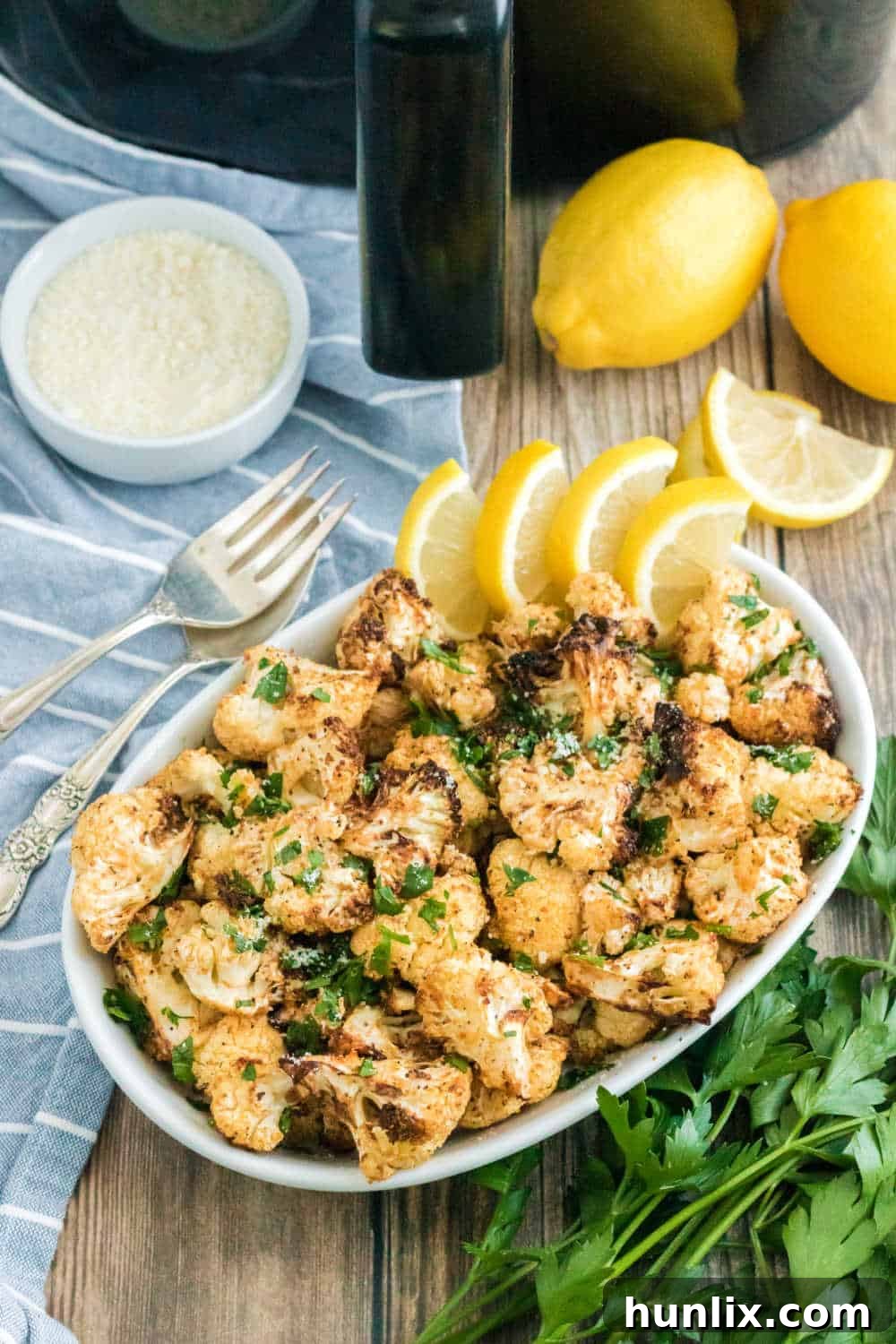 Crispy Air-Fried Cauliflower 2 Air fryer cauliflower on a platter with lemon wedges.