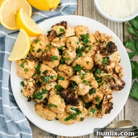 Crispy Air-Fried Cauliflower 10 The recipe on a white plate with lemon wedges.