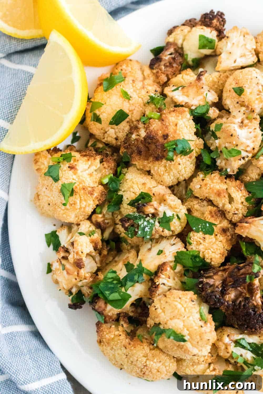 Crispy Air-Fried Cauliflower 7 The recipe on a platter with lemon wedges.