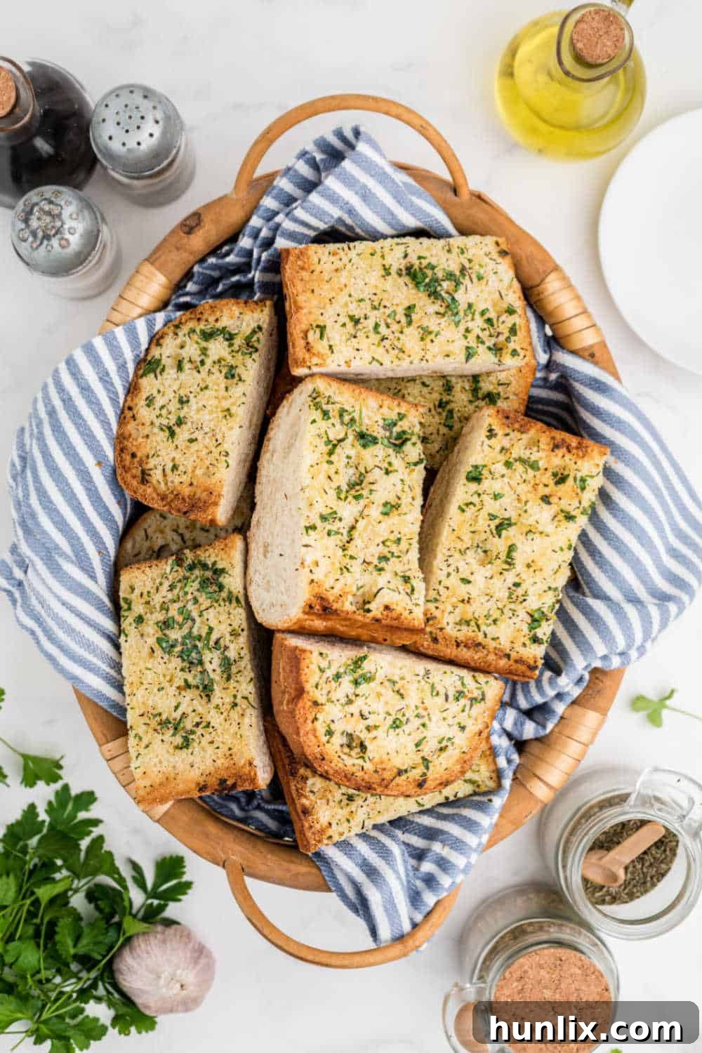 Slices of freshly baked garlic bread, arranged neatly in a rustic woven basket, ready to be served.