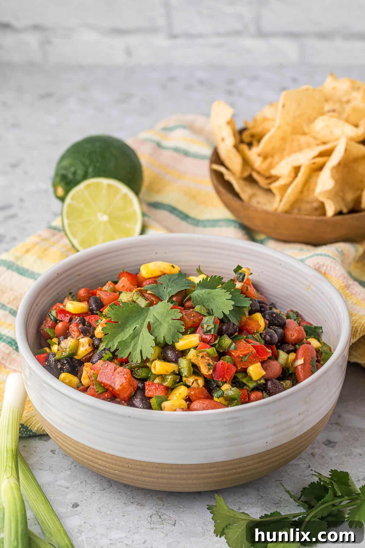 A close-up of a vibrant bowl of Cowboy Caviar with colorful vegetables and beans.