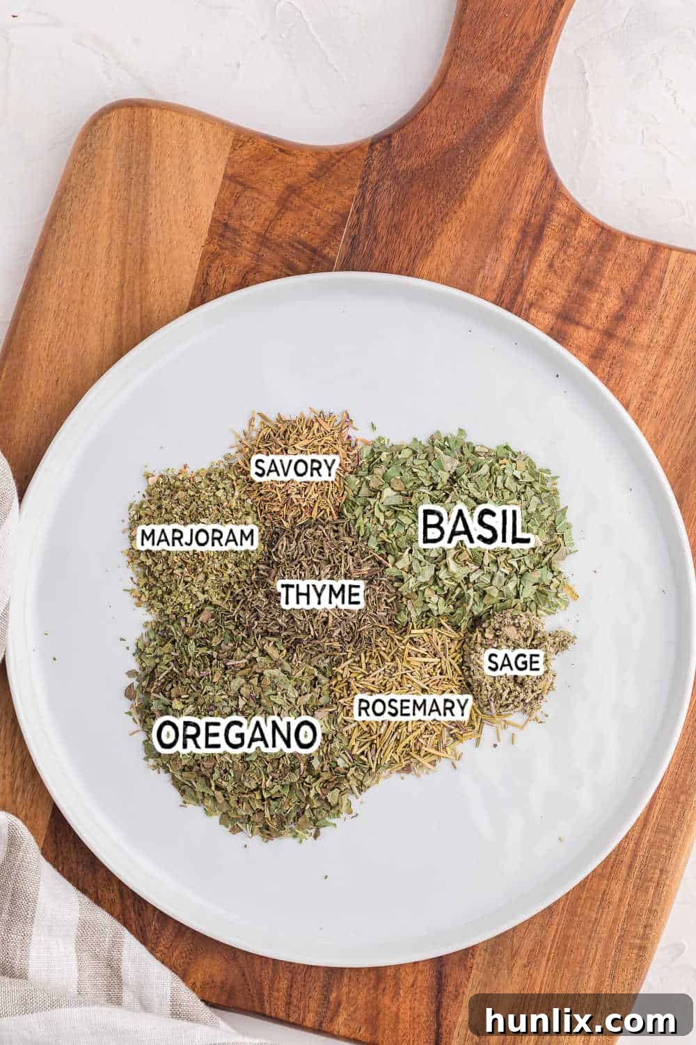 Individual ingredients, neatly arranged, ready to be blended for Italian seasoning.