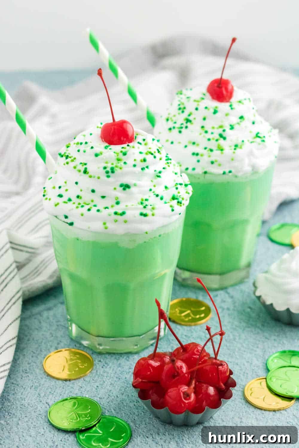Emerald Dream Shake 5 Two glasses of the homemade Shamrock Shake surrounded by festive St. Patrick's Day decorations.