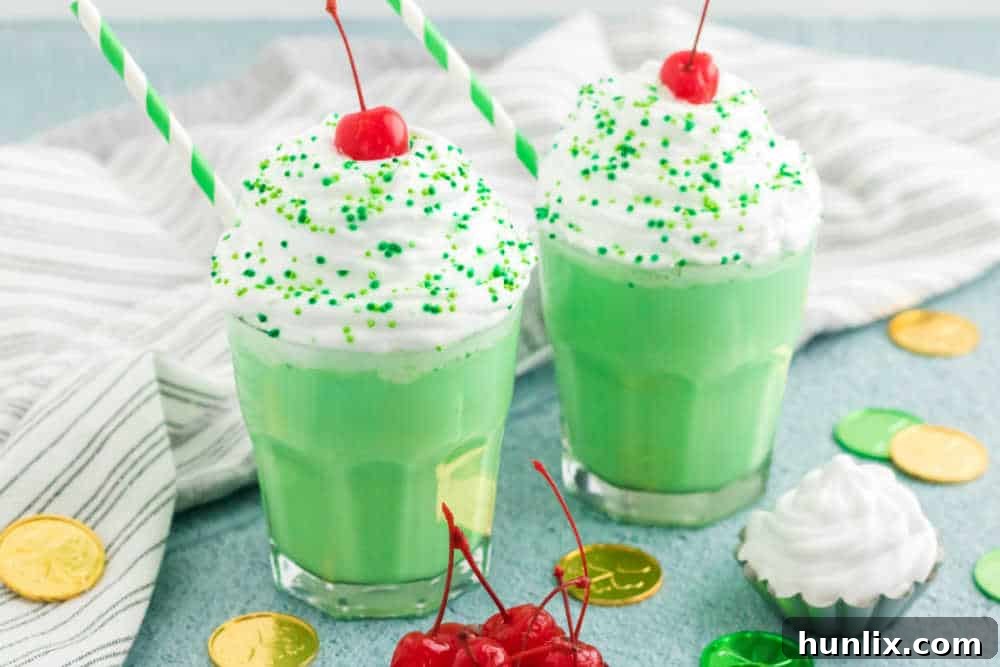 Emerald Dream Shake 6 Two perfectly poured glasses of Shamrock Shake, topped with whipped cream and cherries.