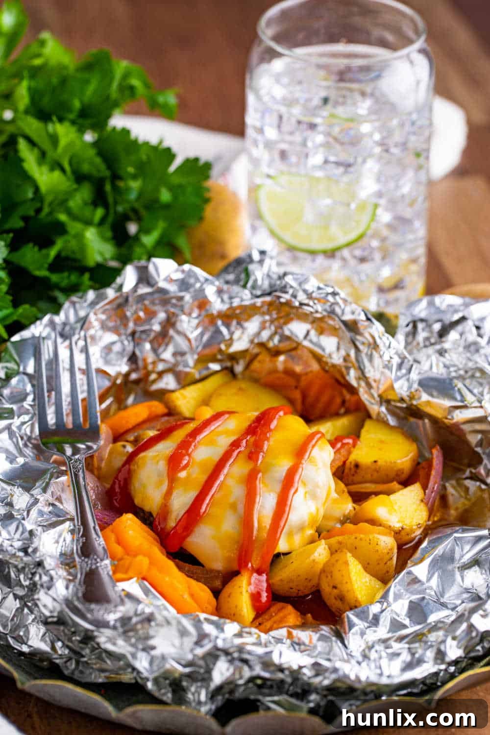 Fireside Burger Pockets 2 Burger hobo packets opened up with a fork inside.