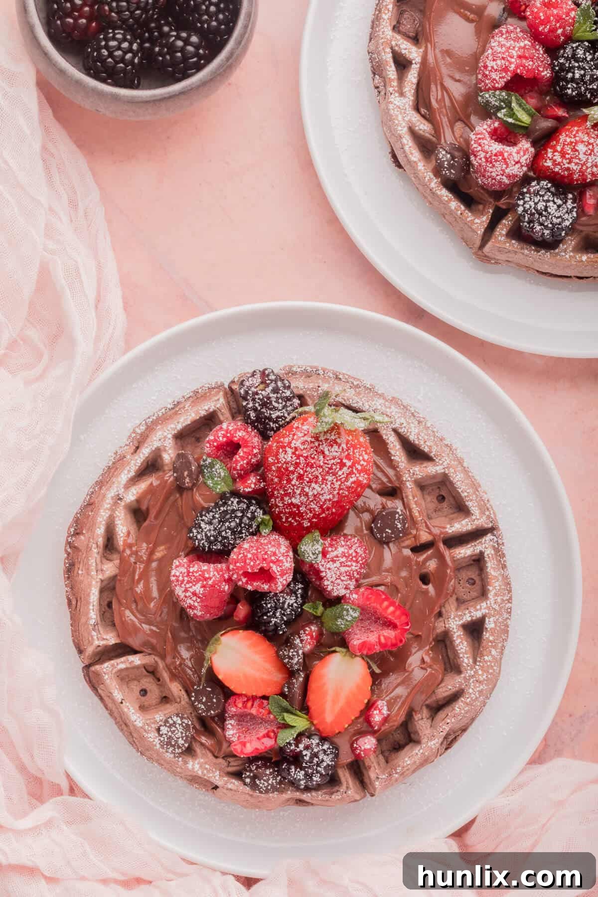 Pure Chocolate Waffle Bliss 9 An enticing plate of chocolate waffles lavishly topped with chocolate syrup and a mix of fresh berries.