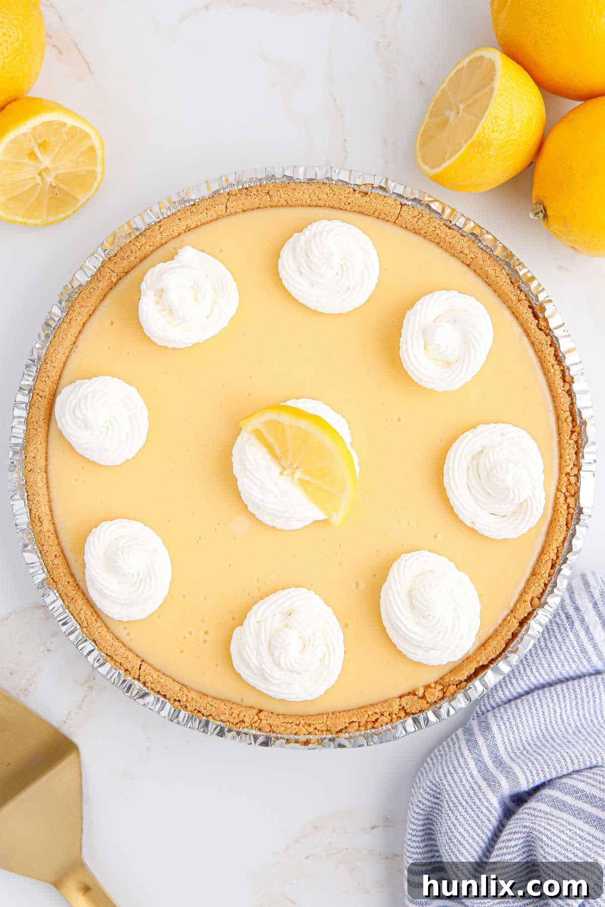 A classic lemon pie garnished with whipped cream and a lemon slice.