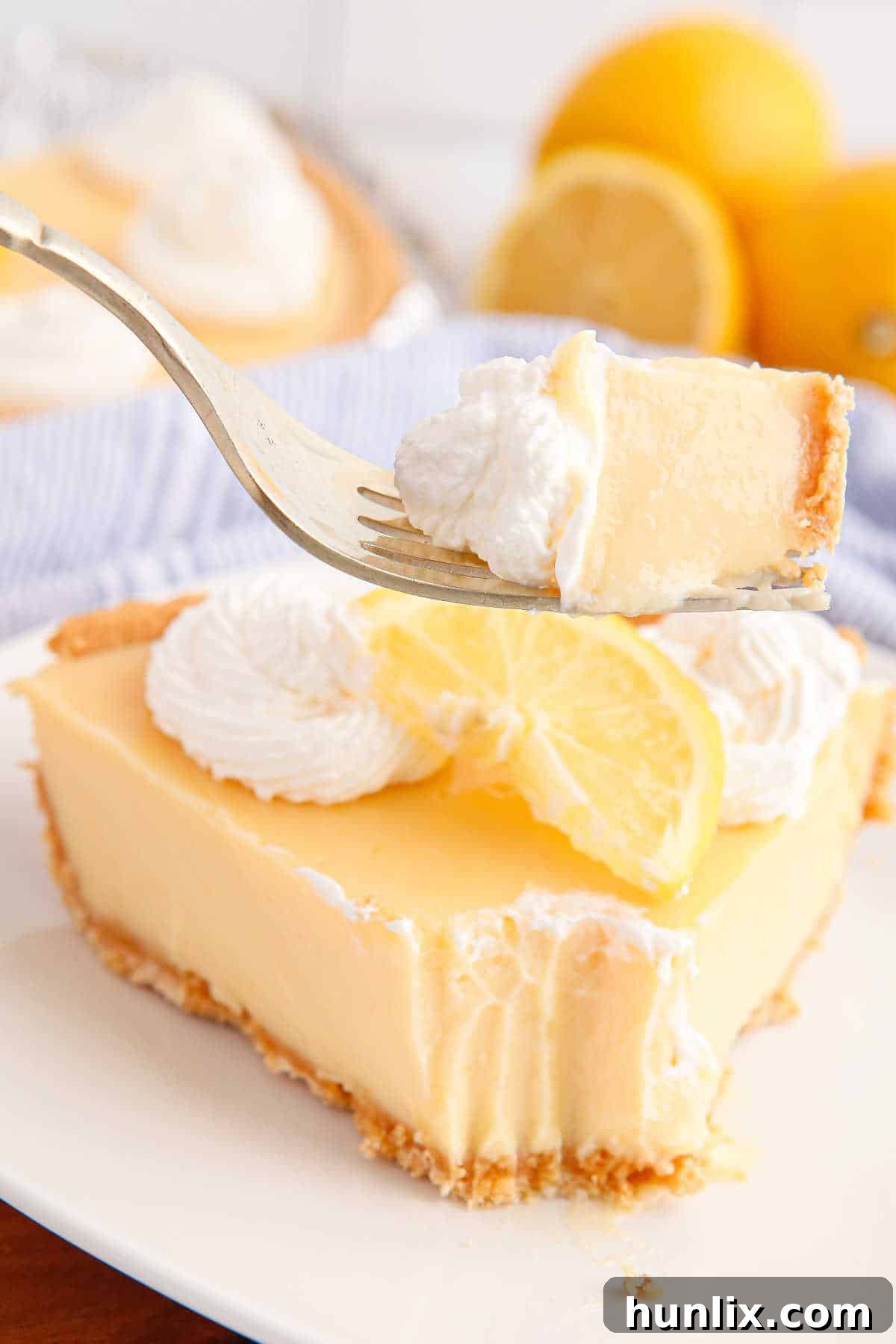 A bite of classic lemon pie on a fork.