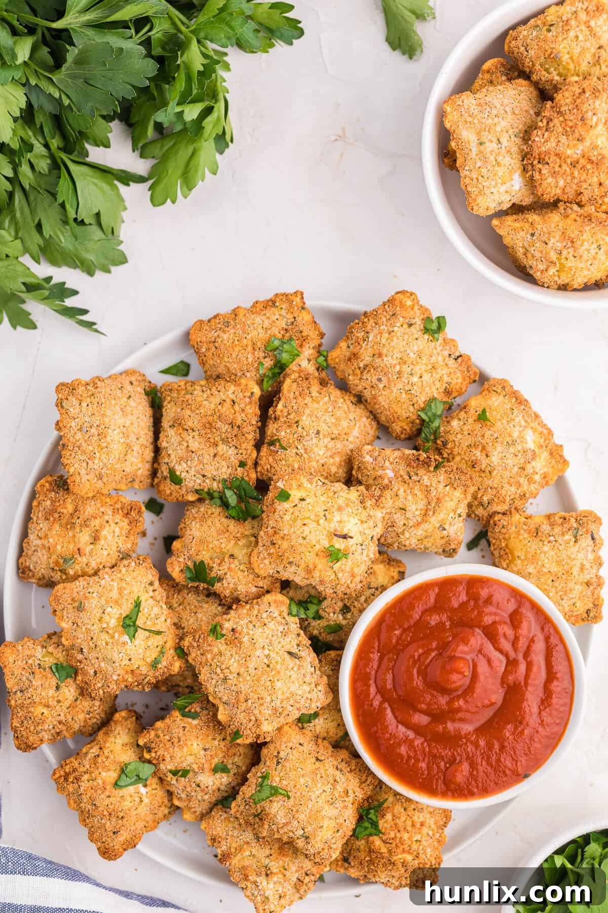 Golden Air Fryer Ravioli 2 A plate of air fryer ravioli with marinara sauce.