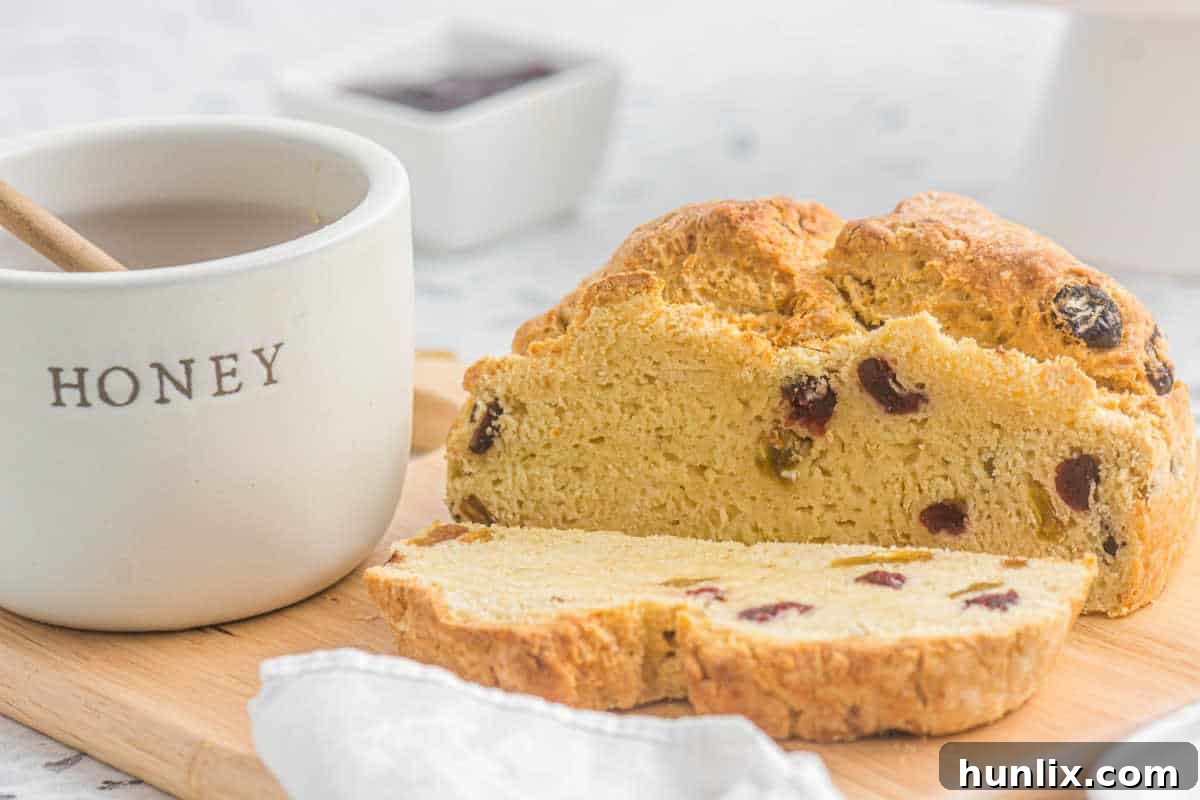 Several thick slices of Irish Soda Bread arranged on a rustic wooden cutting board, ready for serving.