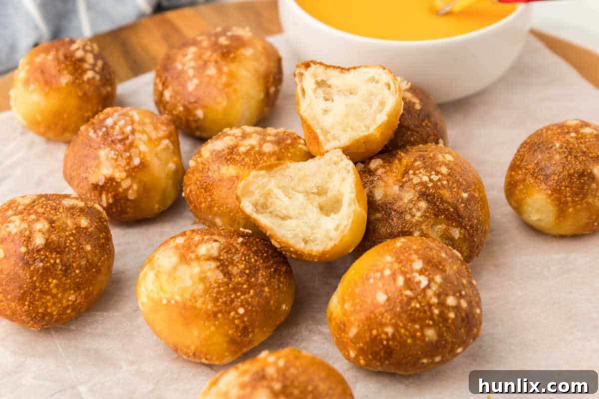 Golden Air Fryer Pretzel Poppers 6 A plate of golden brown air fryer pretzel bites on parchment paper.