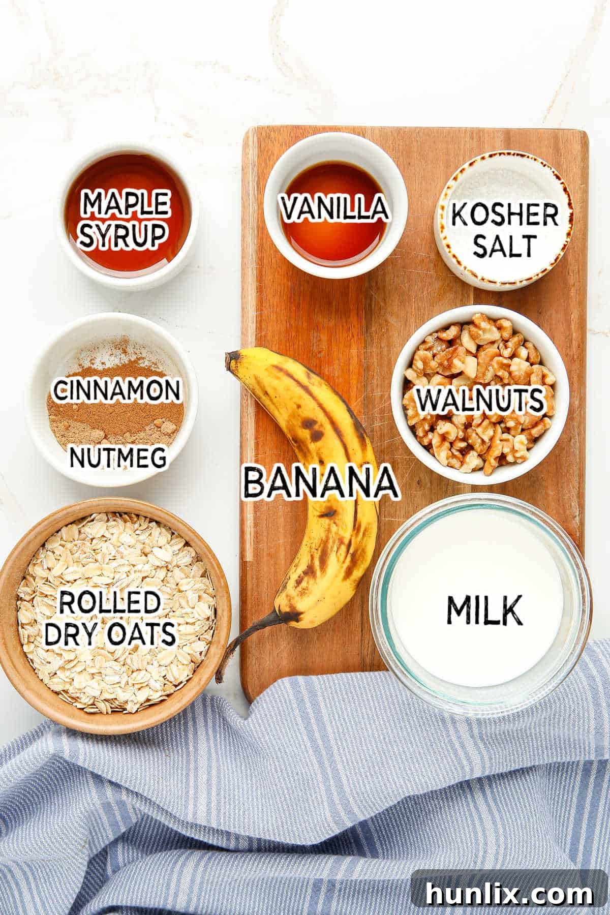 Overhead shot of all the ingredients for Banana Bread Overnight Oats laid out on a wooden cutting board.