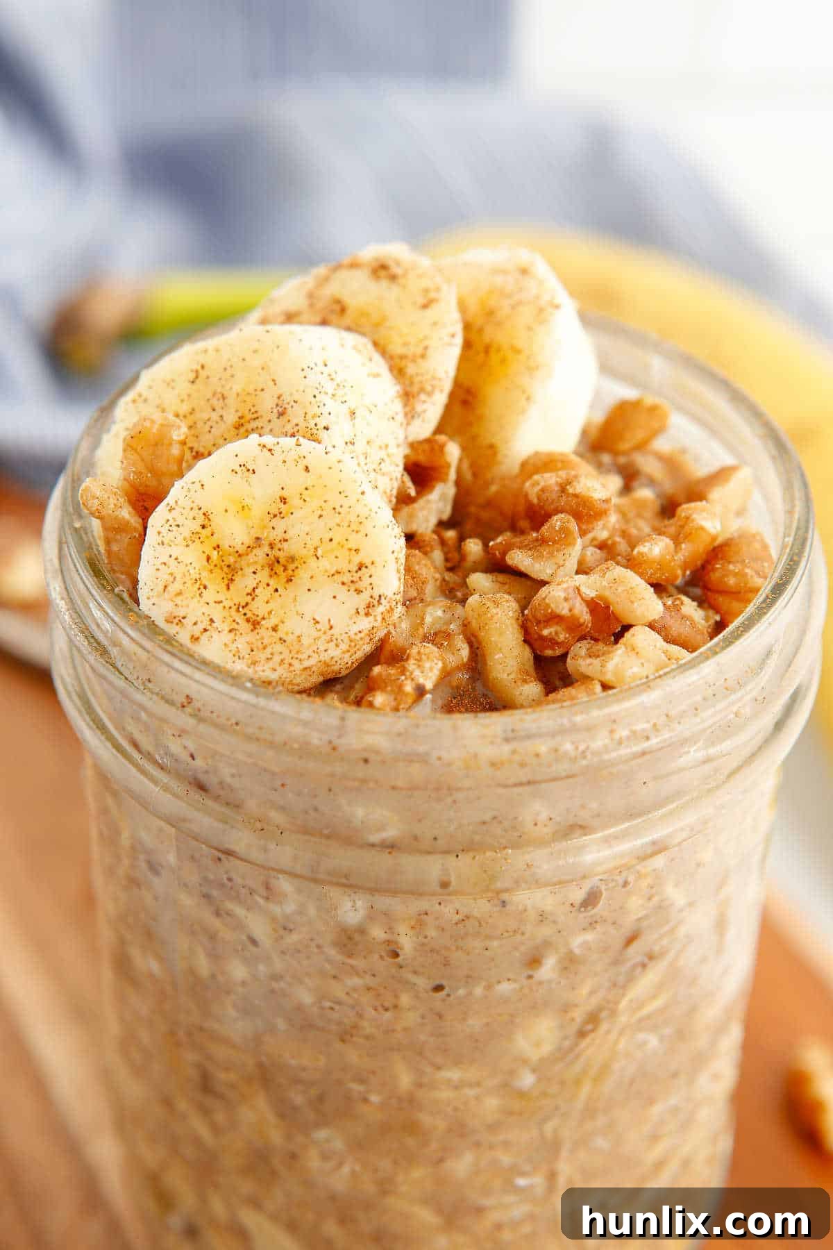 A perfectly prepared mason jar of Banana Bread Overnight Oats, showing layers and toppings.