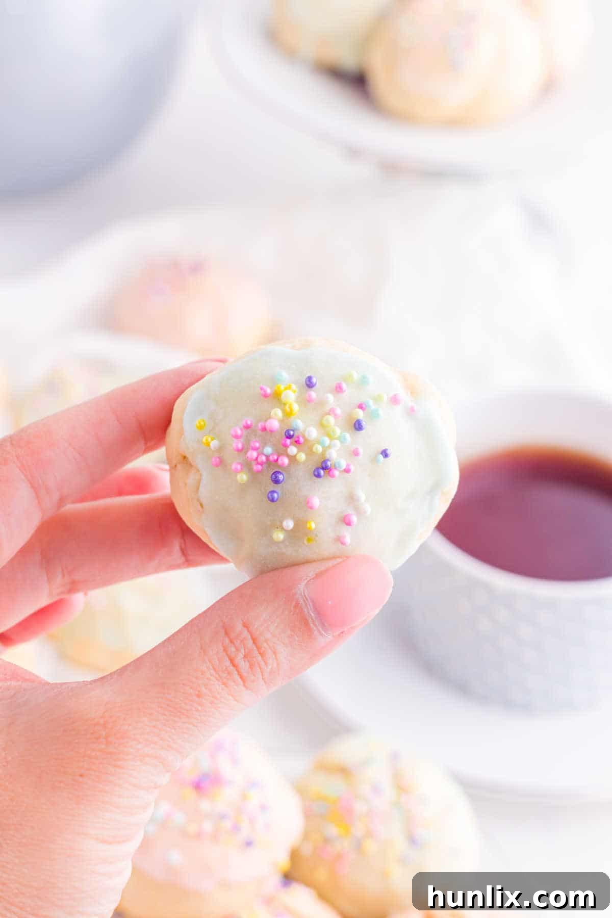Sweet Italian Easter Delights 12 A hand gently holding an Italian Easter Cookie, showcasing its texture and glaze.