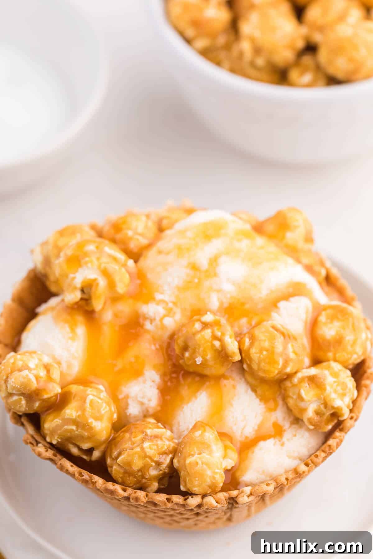 Golden Caramel Crunch Sundae 3 Close-up of a Caramel crunch ice cream sundae showing the layers of ice cream, caramel, and popcorn.