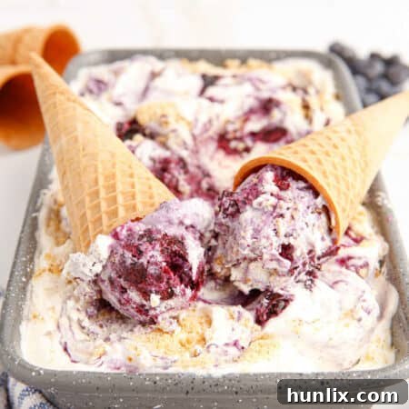 Scoops of Blueberry Pie Ice Cream in a bowl, ready to be enjoyed.