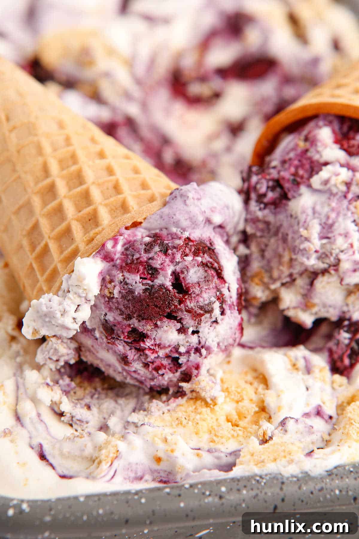 Multiple blueberry pie ice cream cones artfully arranged in a container of the frozen dessert, showcasing the delicious possibilities of customization.