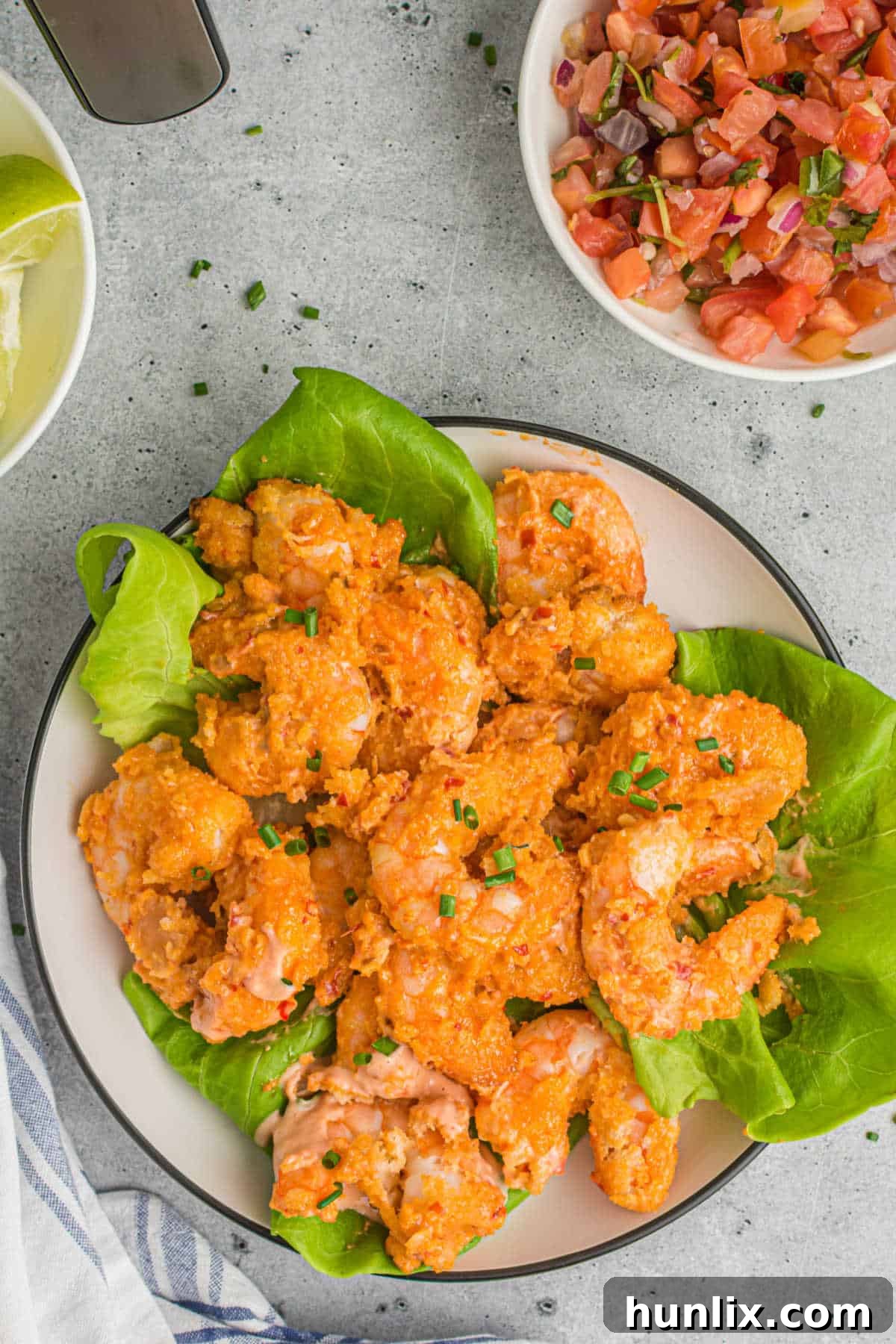 Crispy Air Fryer Bang Bang Shrimp 7 Air Fryer Bang Bang Shrimp served on a bed of fresh green lettuce, ready to be enjoyed.