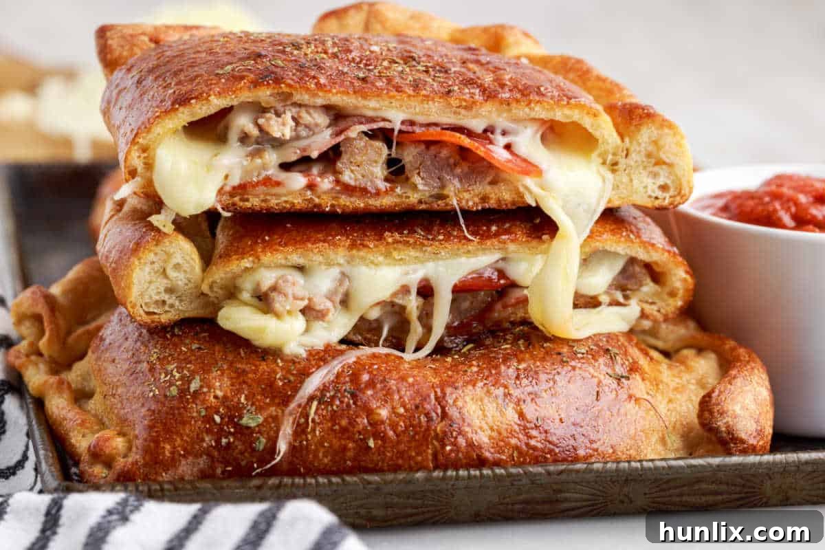 A perfectly baked meat calzone, sliced open to reveal its abundant, cheesy, and meaty filling, ready to be enjoyed.