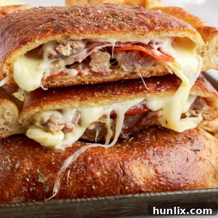 Meat calzone cut in half and piled on top of each other.