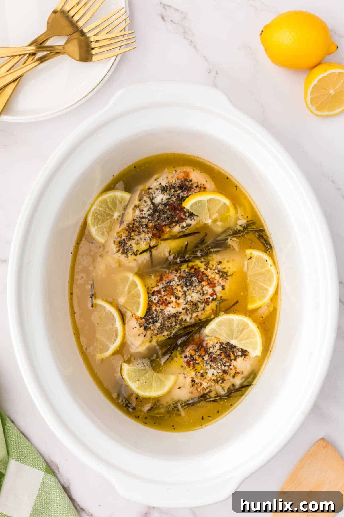 Lemon garlic butter chicken in a white slow cooker.