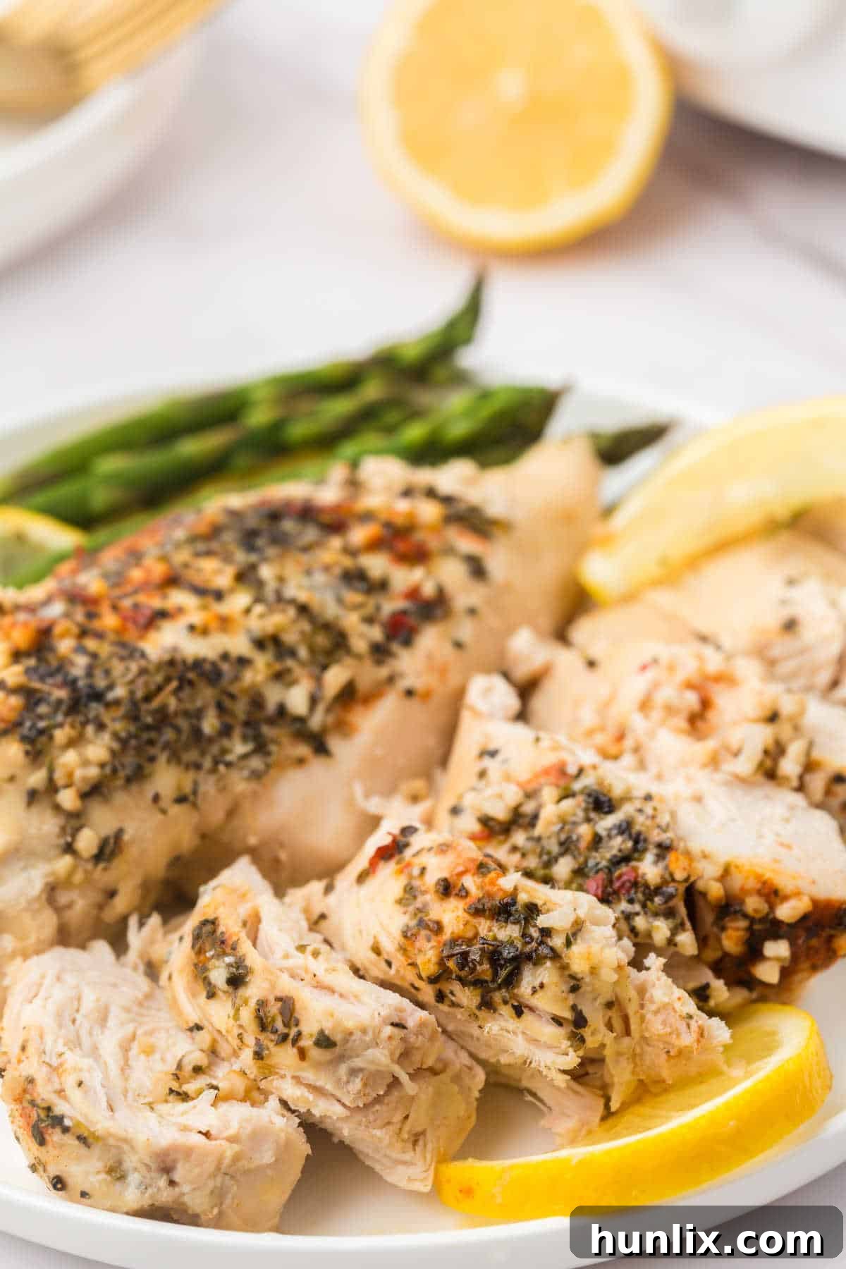 Crockpot lemon garlic butter chicken sliced on a plate.