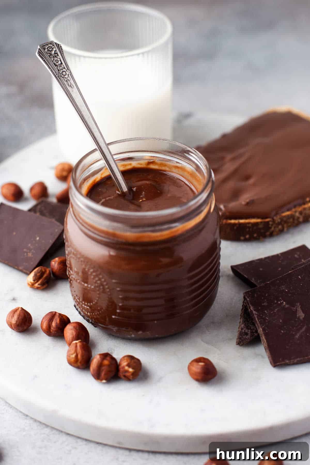 Decadent Homemade Chocolate Hazelnut Spread 2 A glass jar filled with smooth homemade Nutella, with a spoon resting inside, ready to be enjoyed.