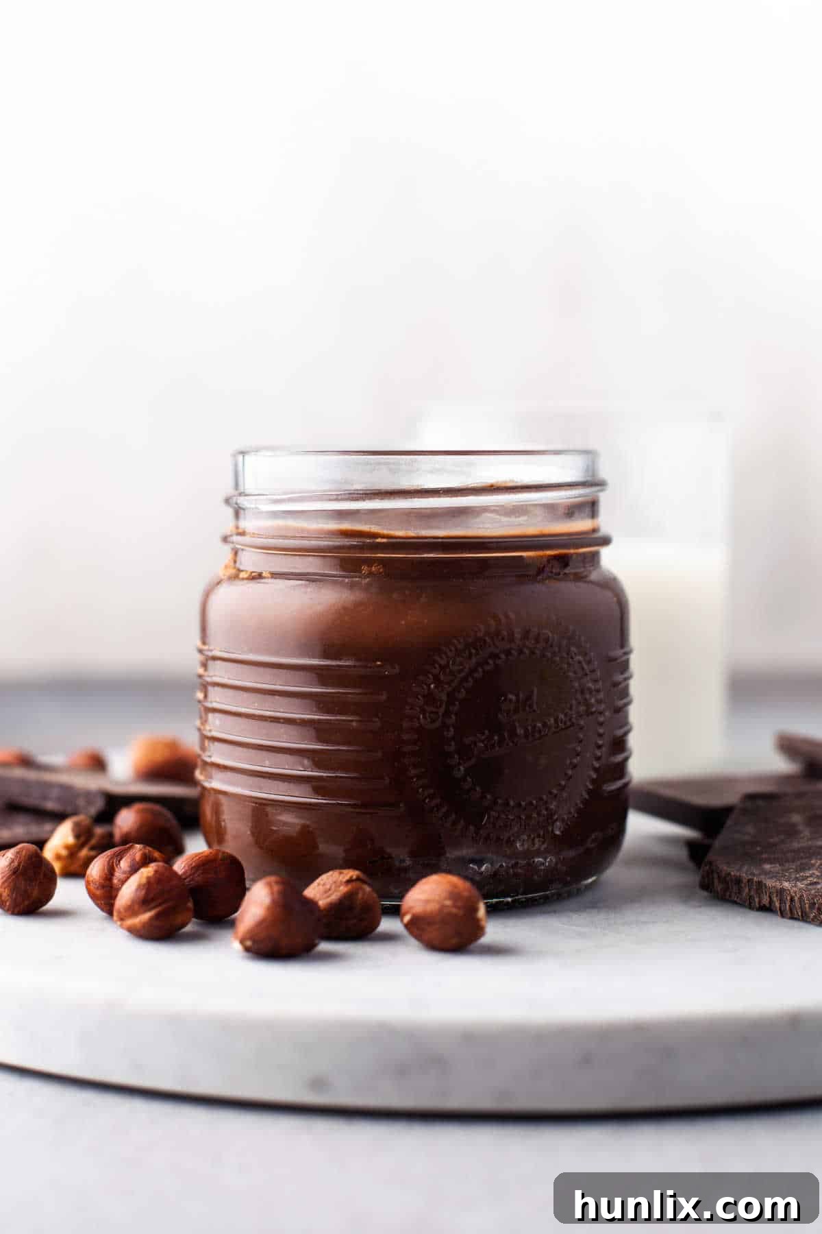 Decadent Homemade Chocolate Hazelnut Spread 11 A glass jar filled with luscious homemade Nutella, captured with a clean, appealing aesthetic.