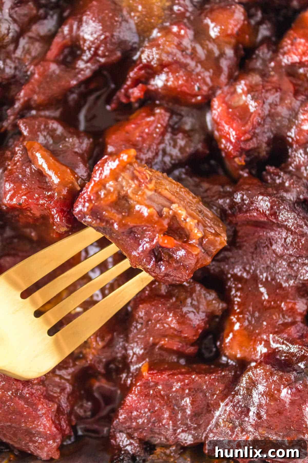 A single Poor Man's Burnt End on a gold fork, showing its tender texture.
