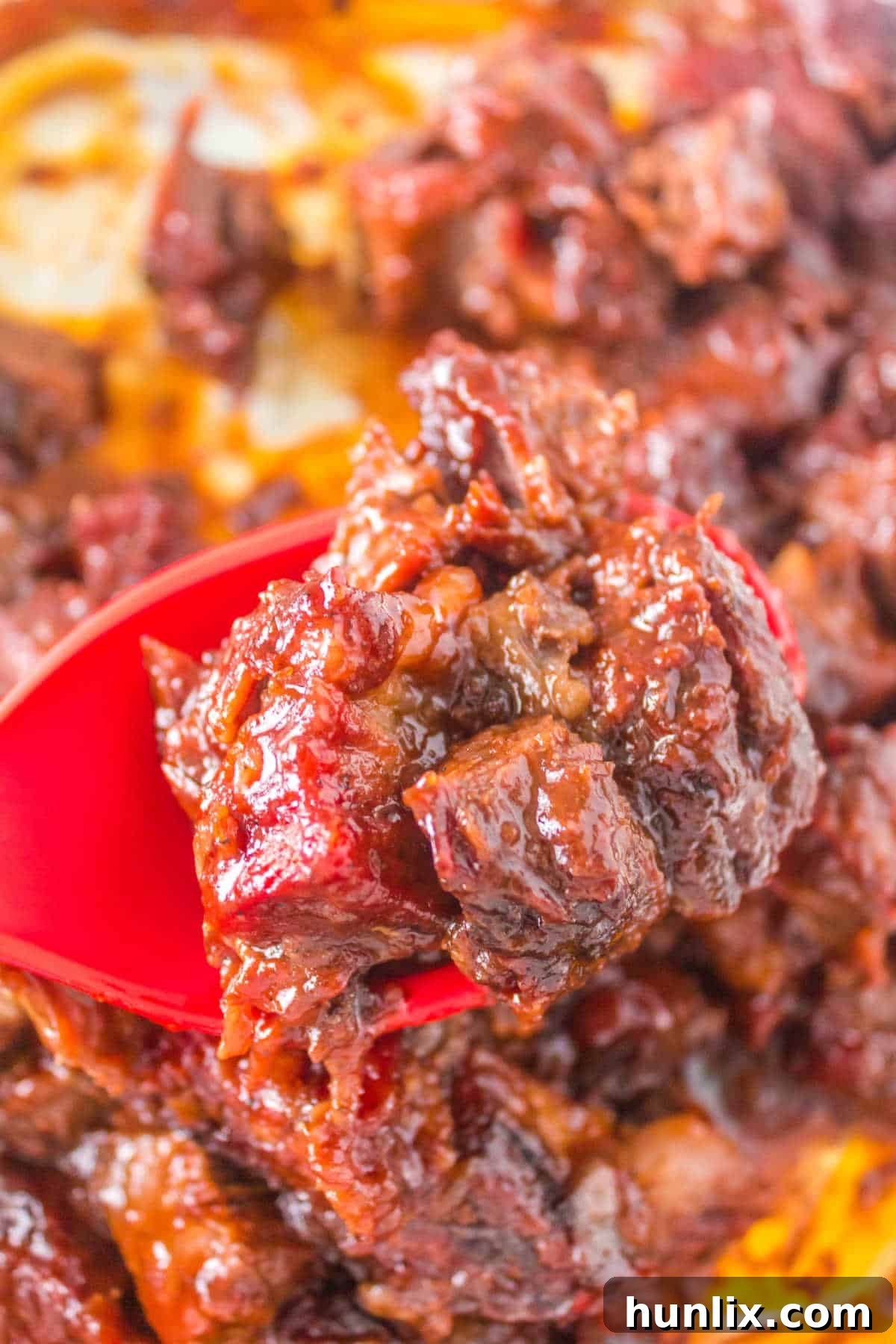 Several Poor Man's Burnt Ends on a red serving spoon.