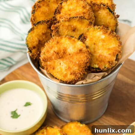 Golden Crispy Air Fryer Zucchini 10 Close-up image of golden, crispy air fryer zucchini chips in a metal serving tin.