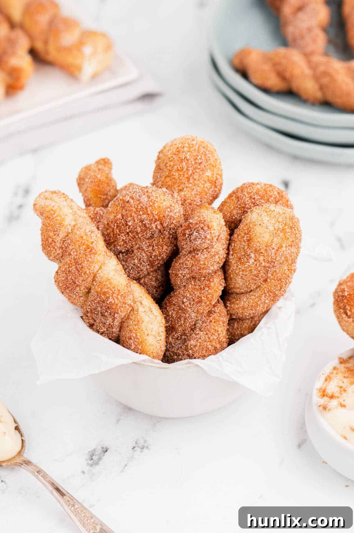 Air fryer cinnamon twists served in a white bowl, ready for enjoyment.